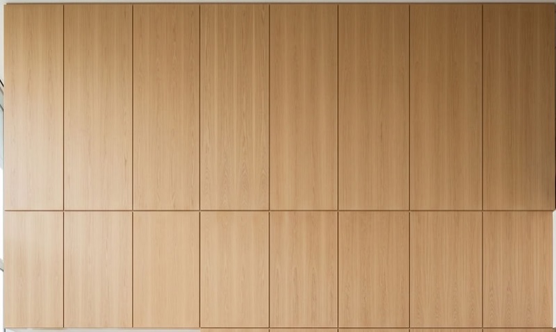 Full-height white oak panelled millwork wall in a commercial lobby